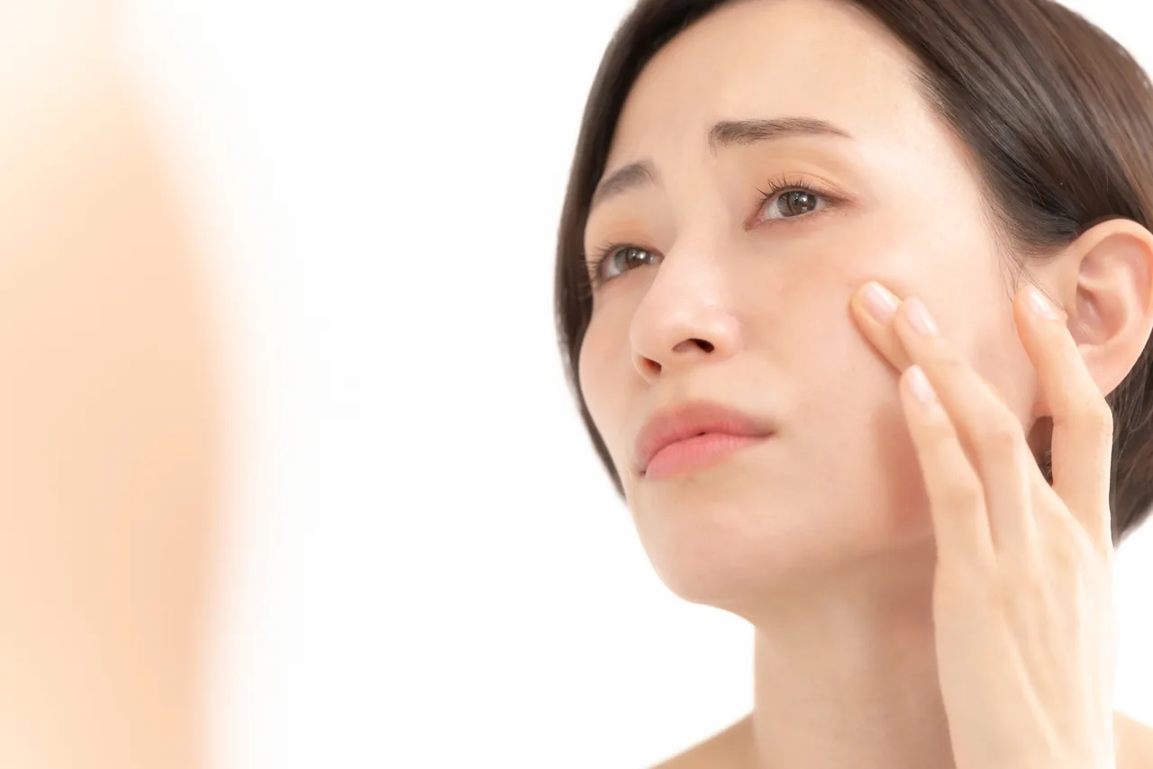 頬のニキビを気にする女性