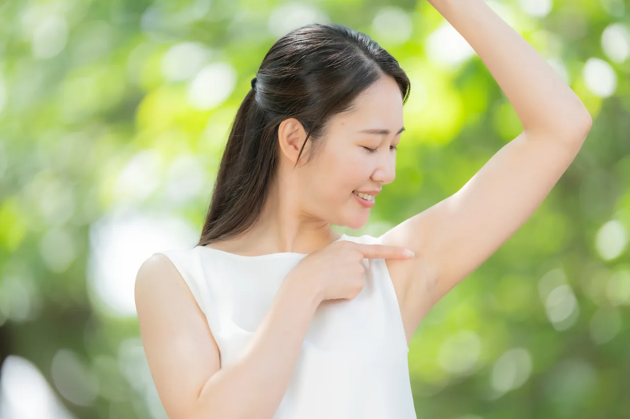 わきを指して笑顔を見せる女性